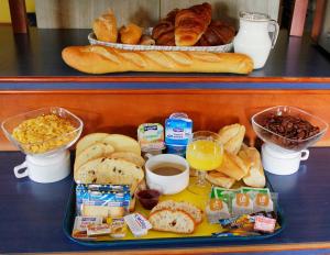 una bandeja de pan y otros alimentos para el desayuno en una barra en ibis Budget La Teste Bassin d'Arcachon, en La Teste-de-Buch