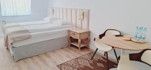 um pequeno quarto com uma cama e uma mesa em W Krainie Alicji em Nałęczów