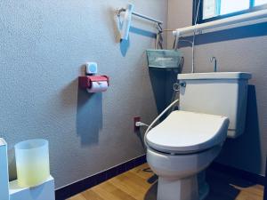 een badkamer met een wit toilet in een stal bij SNOOPYと過ごす一棟貸しの宿 ーacchicocchi hideoutー in Fukushima