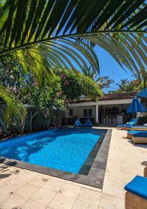 una piscina con palme e una casa di Indigo Bungalows a Gili Trawangan