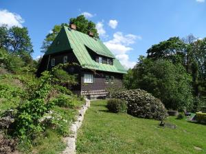 uma casa com um telhado verde numa colina em Prawdzicówka em Zachełmie