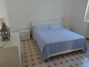 Schlafzimmer mit einem Bett mit blauer Decke in der Unterkunft Casa Archi Santa Cesarea Terme in Santa Cesarea Terme