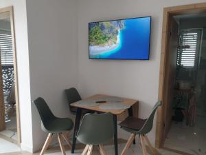 a table and chairs with a tv on a wall at PALAR Apartment in Ljubljana