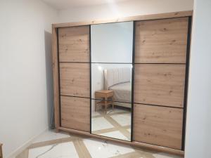 a large wooden wardrobe with a mirror in a room at PALAR Apartment in Ljubljana