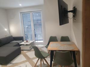 a living room with a couch and a table and chairs at PALAR Apartment in Ljubljana