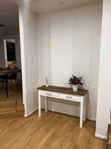 Una habitación blanca con una mesa con una planta. en Family home- close to Knox City & Dandenong Ranges, en Wantirna South