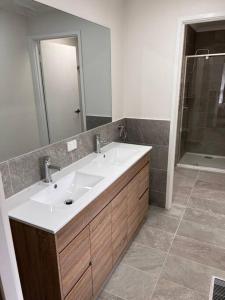 y baño con lavabo y ducha. en Family home- close to Knox City & Dandenong Ranges, en Wantirna South