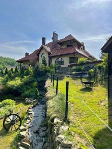 une maison avec un mur en pierre à côté d'une rivière dans l'établissement Apartament Zimowa Cisza, à Piwniczna-Zdrój