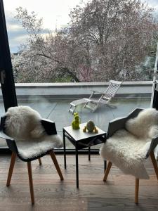 a living room with two chairs and a table and a window at Zum EM Stadion zu Fuß - Luxus im Grünen in Cologne