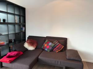 a brown couch in a living room with pillows at Zum EM Stadion zu Fuß - Luxus im Grünen in Cologne