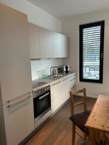 a kitchen with white cabinets and a table and a window at Zum EM Stadion zu Fuß - Luxus im Grünen in Cologne