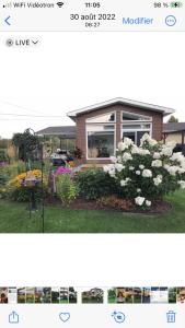 una foto di una casa con un giardino fiorito di Oasis de la rivière a Saguenay