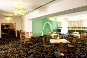 d'une salle à manger avec des tables, des chaises et des murs verts. dans l'établissement AKTIVHOTEL Weisser Hirsch, à Mariazell