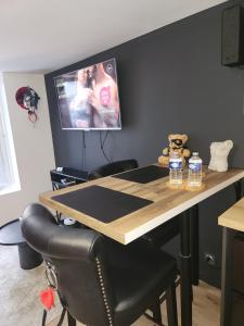 a table with a teddy bear and two bottles of water at Studio Le Miroir Rouge in Meaux