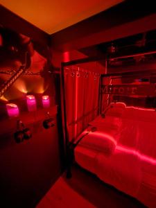 a red bedroom with a bed with pink lights at Studio Le Miroir Rouge in Meaux