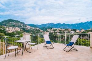 a balcony with chairs and a table with a view at Palazzo Pascal in Scala