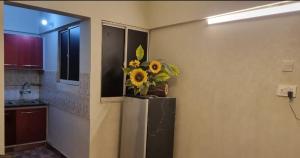 a kitchen with a vase of sunflowers on a refrigerator at Furnished One Bedroom appartment with kitchen in Karachi