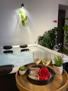 un tavolo con 2 bicchieri di vino e una vasca idromassaggio di SPAYA JACUZZI centrum apartment - with home cinema & private parking a Košice