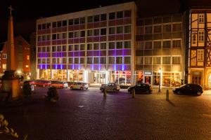 een gebouw met auto's geparkeerd op een parkeerplaats 's nachts bij Hotel Platzhirsch in Fulda