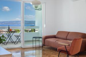 a living room with a couch and a view of the ocean at Skyline Suite in Omiš