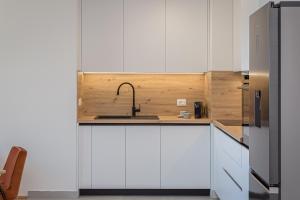 a kitchen with white cabinets and a sink at Skyline Suite in Omiš