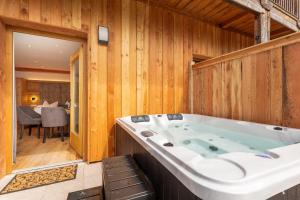 a large bath tub in a room with wooden walls at Luxus-Appartement mit Whirlpool und Sauna #531 in Ainring