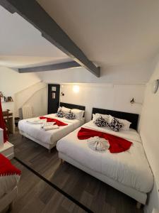 2 camas en una habitación con rojo y blanco en HOTEL LOUVAIN, en París