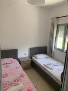 - une chambre avec 2 lits et une fenêtre dans l'établissement Villas Ermali, à Ksamil