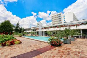 un hôtel avec une piscine et un bâtiment dans l'établissement Ensana Splendid, à Piešťany