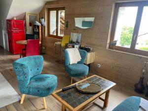 sala de estar con 2 sillas y mesa en Maison d'hôtes des Bassins d'Oche, en Saint-Paul-en-Chablais