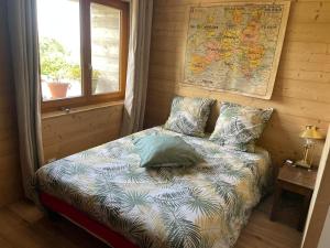 Cama pequeña en habitación con mapa en la pared en Maison d'hôtes des Bassins d'Oche, en Saint-Paul-en-Chablais