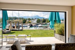 une terrasse avec vue sur le port de plaisance et ses tables et chaises. dans l'établissement Boutiquehotel Wörthersee - Serviced Apartments, à Velden am Wörther See