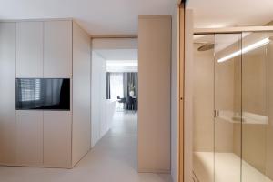 un couloir avec une porte coulissante en verre et un salon dans l'établissement Boutiquehotel Wörthersee - Serviced Apartments, à Velden am Wörther See