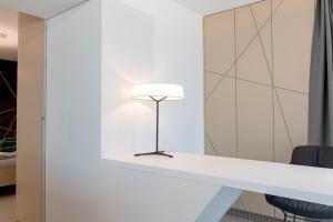 une lampe assise sur un comptoir blanc dans une pièce dans l'établissement Boutiquehotel Wörthersee - Serviced Apartments, à Velden am Wörther See