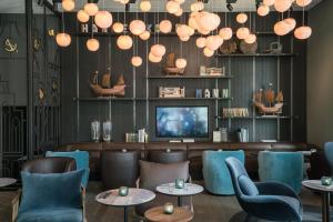 un restaurante con sillas y mesas azules y TV en Motel One Lübeck, en Lübeck