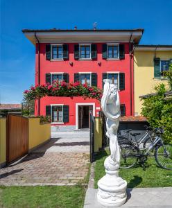 una estatua blanca delante de un edificio rojo en B&B Il Giardino dei Poeti and Apartaments, en Lucca