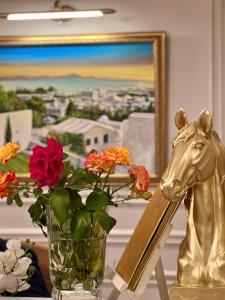 a table with a vase of flowers and a statue of a horse at La Menara Hotel & SPA in Sidi Bou Saïd