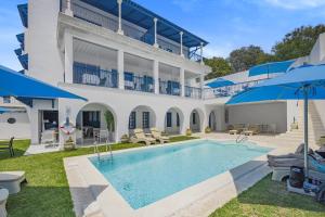 ein großes weißes Haus mit einem Pool in der Unterkunft La Menara Hotel & SPA in Sidi Bou Saïd