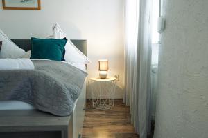 um quarto com uma cama e um candeeiro sobre uma mesa em Charmantes Privatzimmer in der Stadt em Koblenz