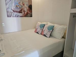 un letto bianco con due cuscini sopra di Corfu Glyfada Beach Apartment 13 a Glifada (Glyfada)