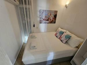 un piccolo letto bianco con due cuscini sopra di Corfu Glyfada Beach Apartment 13 a Glifada (Glyfada)