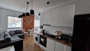 Il dispose d'une cuisine et d'un salon avec un canapé et une table. dans l'établissement Apartament Zamkowy, à Lublin