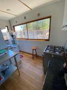 una cucina con piano cottura in una camera con finestra di Casa Cumbre Algarrobo ad Algarrobo