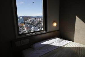 Llit o llits en una habitació de Super Hotel Sano Fujioka