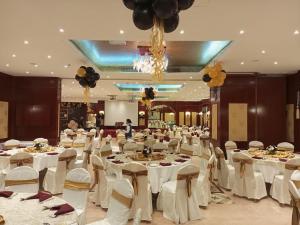 una sala banchetti con tavoli bianchi e sedie bianche di ROYAL CONCORDE HOTEL&SUITE a Dubai