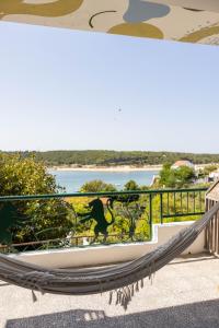 un'amaca sul balcone con vista sull'acqua di MUTE Hostel Milfontes a Vila Nova de Milfontes