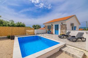 una piscina di fronte a una casa di Holiday house KUNTENTA with pool and jacuzzi a Skrbčići