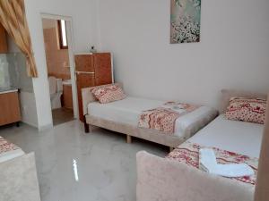 Habitación pequeña con 2 camas y sofá en Prime rooms, en Durrës