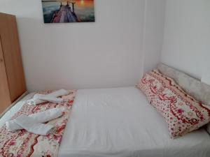 1 cama con 2 almohadas y una foto en la pared en Prime rooms, en Durrës