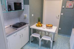 uma pequena cozinha com uma mesa com uma taça de fruta em Diamond dream em Ptuj